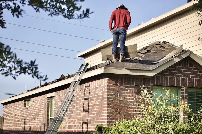 Professional roofer working on a residential roof in Weddington